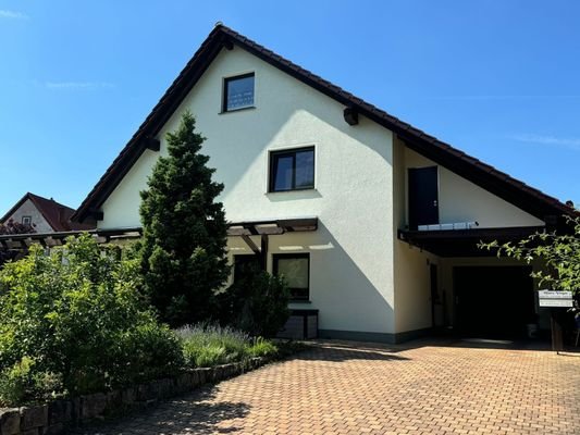 Hausansicht mit Stellplätzen und Carport