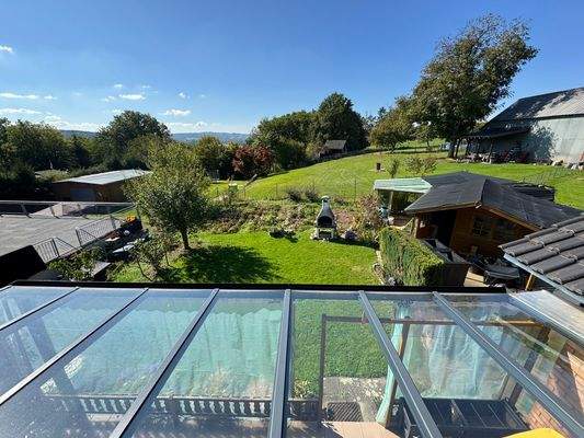 Blick von Balkon auf überdachte Terrasse 