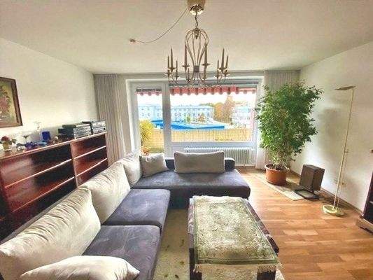 Ein großes Fenster verbindet das Wohnzimmer mit dem Balkon