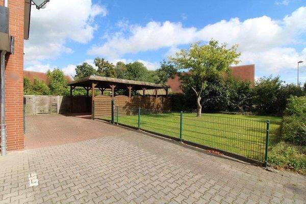 Grünfläche und Doppelcarport neben dem Gebäude