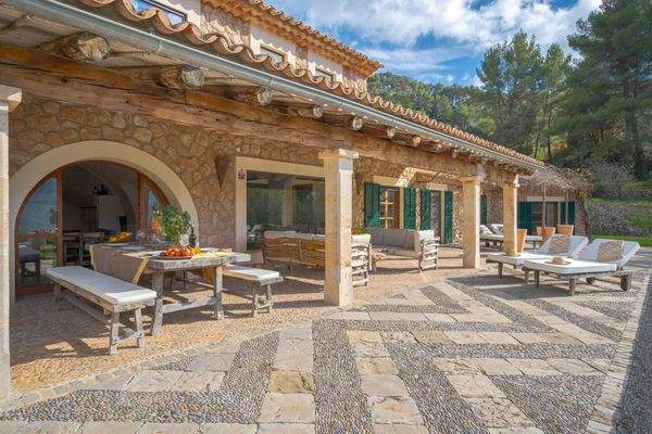 Überdachte Terrasse mit Esstisch und mediterranem Ambiente