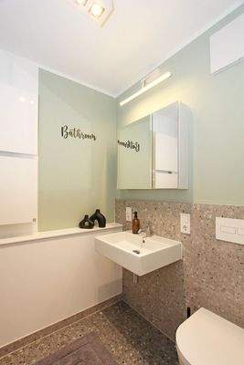 Geräumiges Badezimmer mit Regendusche und WC