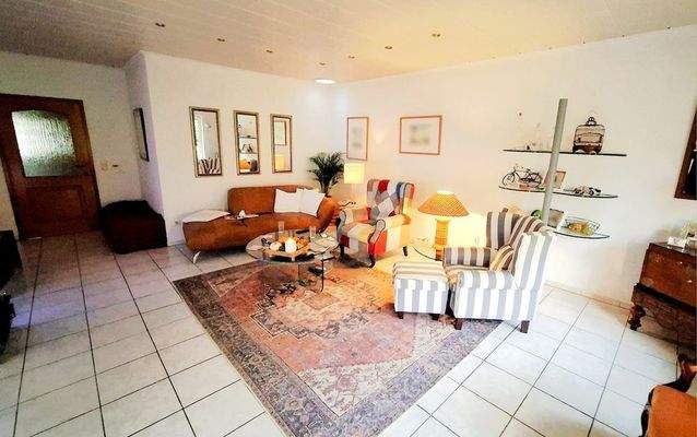 Wohnzimmer mit Zugang zur überdachten Eck-Terrasse