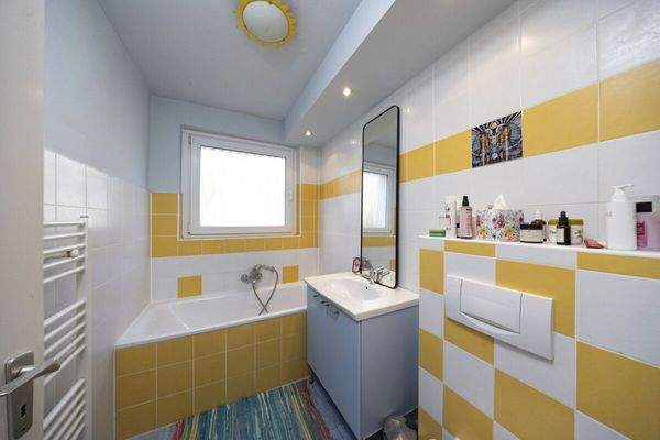 Badezimmer mit Fenster und Badewanne