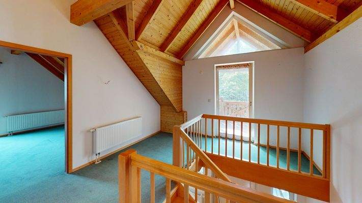 Treppenhaus im Obergeschoss mit Zugang zum Balkon