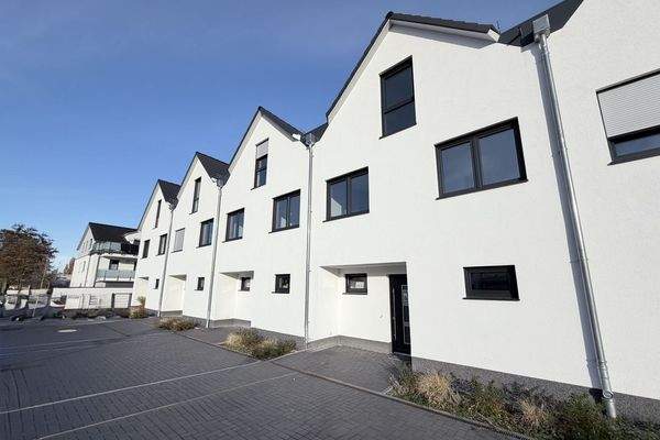 Hausfront mit Parkplätzen