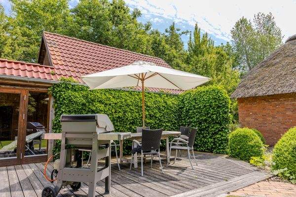 Terrasse mit Grill und Schirm