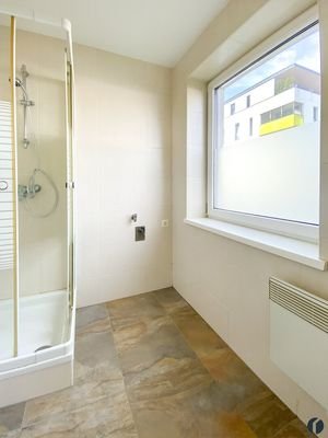 Badezimmer mit Dusche, Waschmaschinenanschluss und Fenster