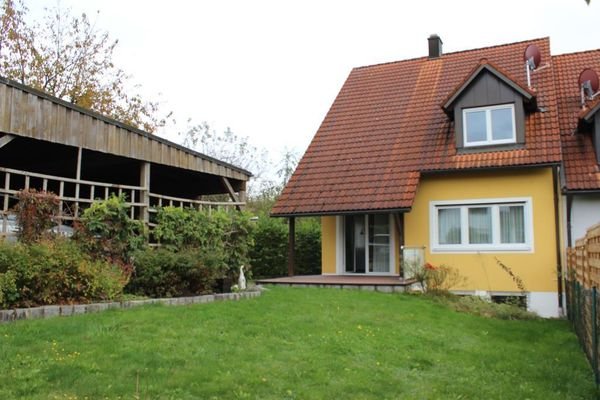 Außenansicht mit Carport und Garten