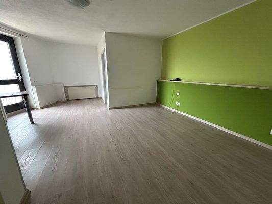 Apartmentzimmer mit Küchenzeile und Balkonzugang