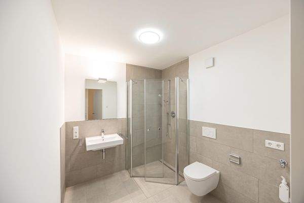 Badezimmer mit bodengleicher Dusche und Waschmaschinenstellplatz