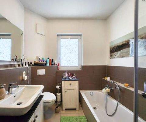 Tageslicht-Badezimmer mit Badewanne, Dusche und zusätzlichem Handtuchheizkörper