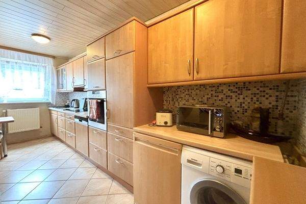 Küche mit Einbauschränken und Waschmaschine