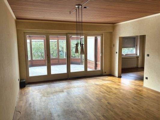 Wohnzimmer mit Zugang zum Esszimmer und Wintergarten