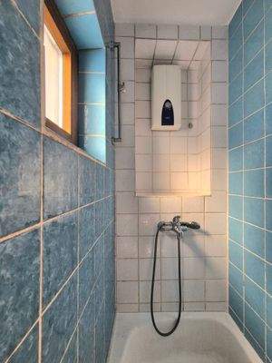 Badezimmer mit Dusche und Fenster