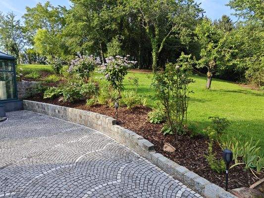 Parkanlage mit gepflegtem Blumenbeet und Grünflächen