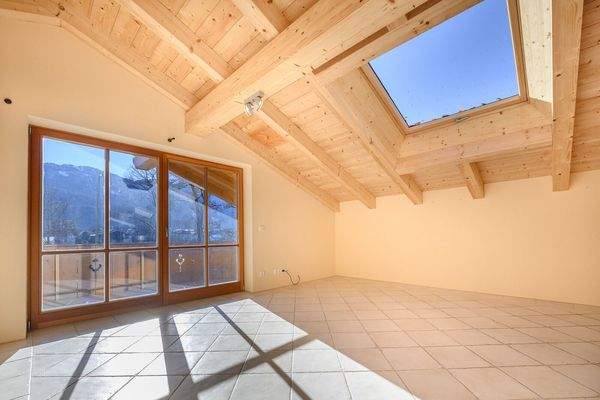 Schlafzimmer mit Sichtdachstuhl und Balkonzugang