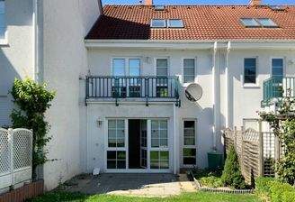 Gartenansicht mit Terrasse und Balkon