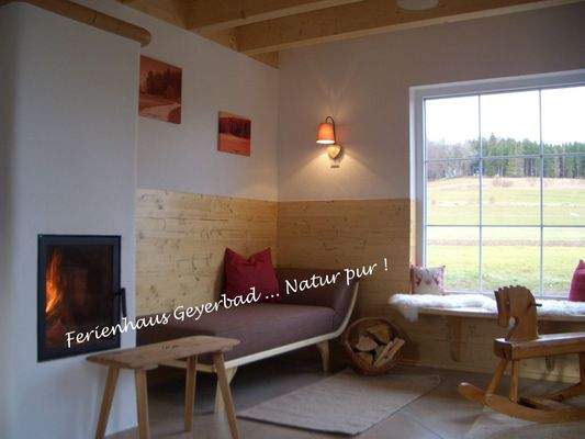 Wohnzimmer mit Holzofen und großem Fenster