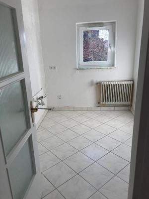 Küche mit weiß angelegten Wänden und weiß-grauen Bodenfliesen