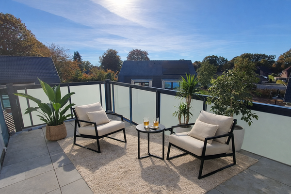 Sonniger Balkon mit Lounge und Pflanzen.png