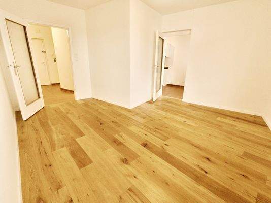 Wohnzimmer mit Zugang zu Küche und Vorzimmer