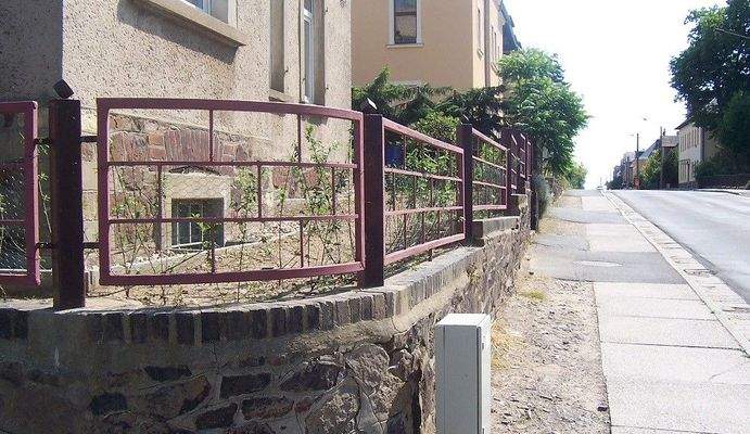 Natursteinmauer mit Eisenzaun