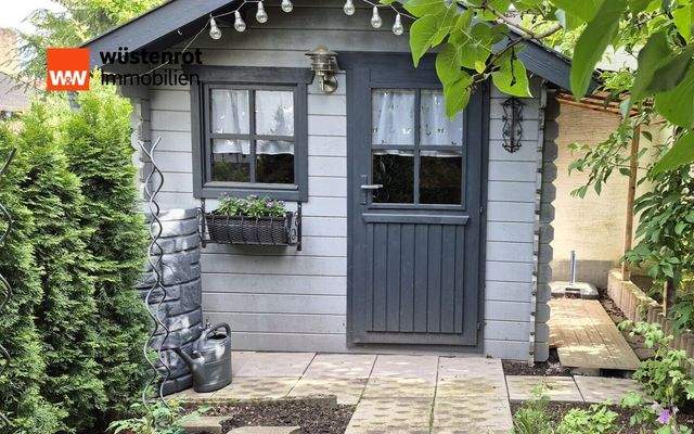 Im Garten steht ein praktisches Gartenhaus für Gartengeräte und Platz für Balkonmöbel und den Grill.