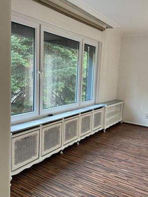 Lichtdurchflutetes Ambiente: Stilvolle Heizkörperverkleidung mit elegantem Sichtschutz und Panoramablick ins Grüne