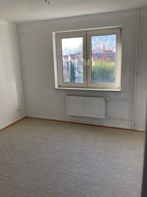 Kinderzimmer mit weiß angelegten Wänden und hellem Vinylboden