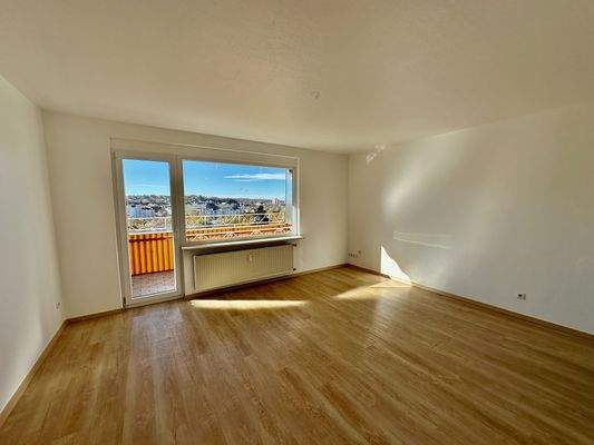 Sonniges Wohnzimmer mit Ausgang zum Balkon
