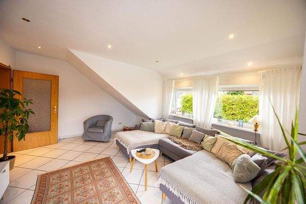 Wohnzimmer mit Gaube über fast die gesamte Zimmerbreite