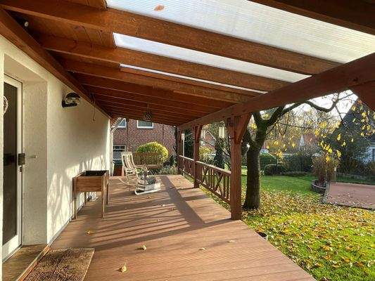 Blick auf den Hauseingang und die überdachte Terrasse