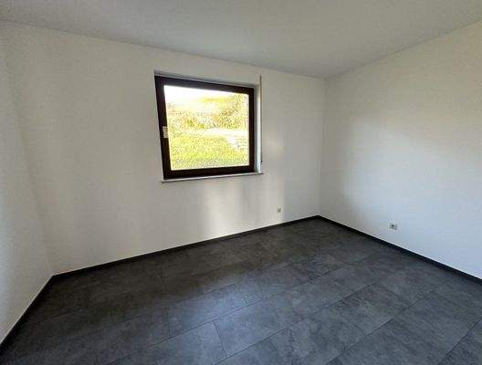 Lichtdurchflutetes Zimmer mit hochwertiger Bodenbeschichtung und Gartenblick