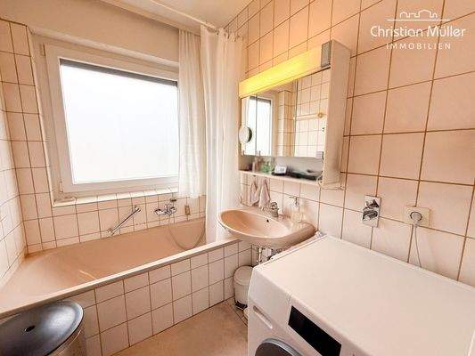 Badezimmer mit Fenster, Badewanne und Waschmaschinenanschluss