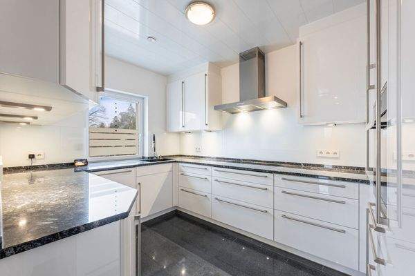 Moderne Einbauküche mit hochwertigen Elektrogeräten und Granit-Arbeitsplatte