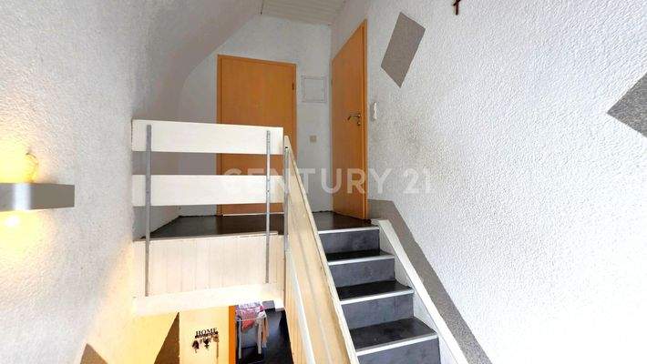 Treppenhaus mit Zugang zu den Zimmern im OG