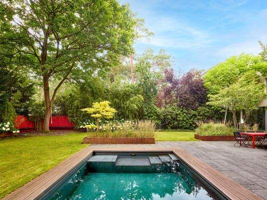 Blick in den großzügigen Garten mit der Poolanlage