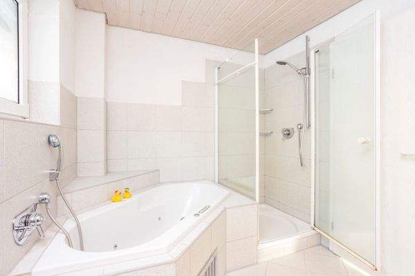 Badezimmer mit Badewanne und Dusche