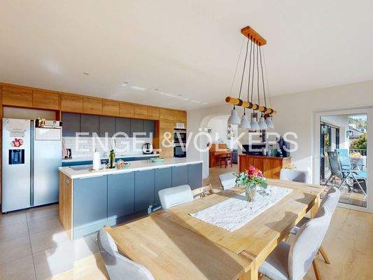 Elegante Küche mit nahtlosem Übergang zum Wohnbereich und Ausgang zum Balkon