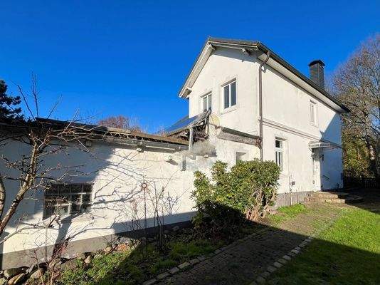 Immobilie mit Anbau von der Seite mit Hauseingang