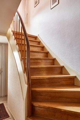 Elegante Holztreppe mit massivem Handlauf - Verbindung zwischen den Wohnebenen