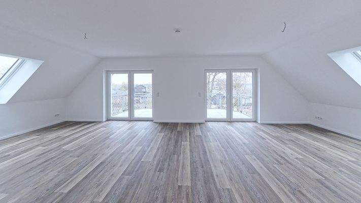 Offener Wohnbereich mit dem Zugang zu einem großen Balkon