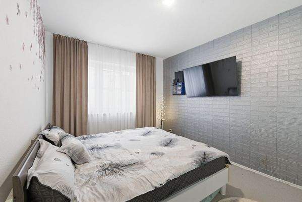 Gemütliches Schlafzimmer mit großen Fenstern