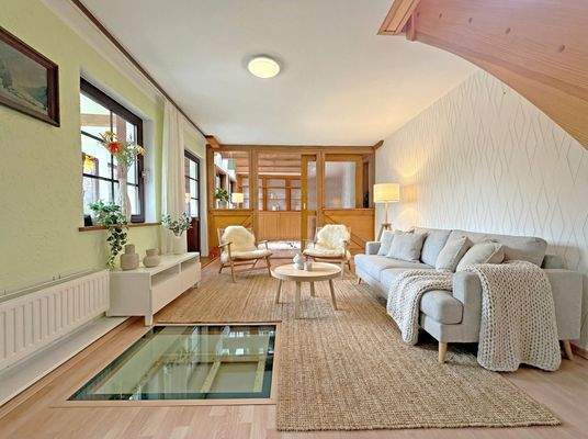Wohnzimmer mit angrenzendem Wintergarten und Loungebereich