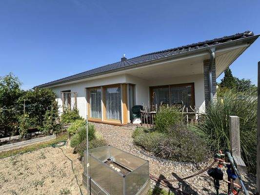 Blick aus dem Garten auf die überdachte Terrasse