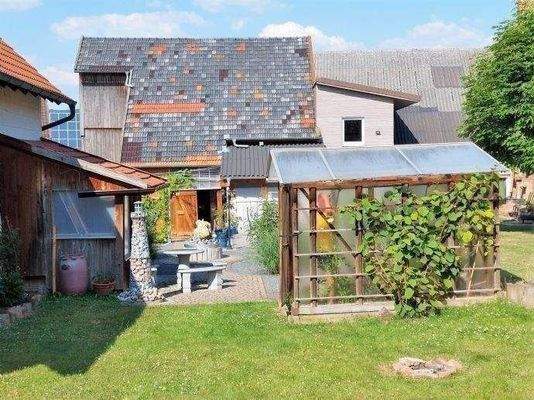 Rückwärtige Ansicht mit Gartenhaus, Gewächshaus.