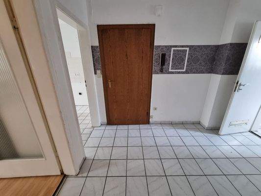 Flur mit Holztür und Fliesen