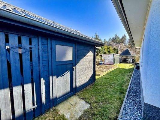 Blick auf das Gartenhaus und die Gemüsebeete an der Westseite des Hauses