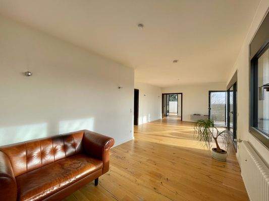 Der große Wohnbereich ist an ein offenes Esszimmer und den großen Balkon an gebunden